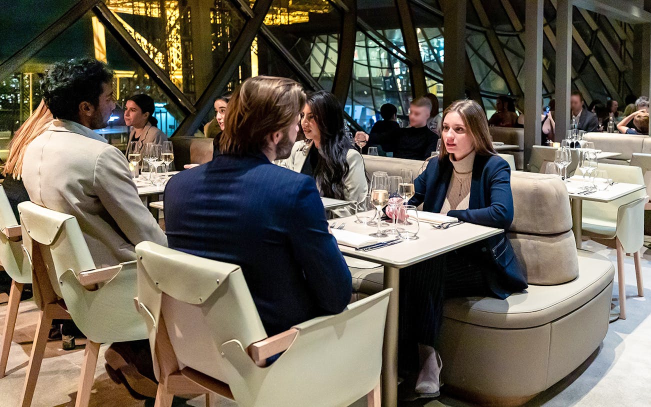 Dining experience on the first floor of the Eiffel Tower, Paris, with guests enjoying Christmas dinner.
