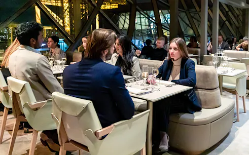 Dining experience on the first floor of the Eiffel Tower, Paris, with guests enjoying Christmas dinner.