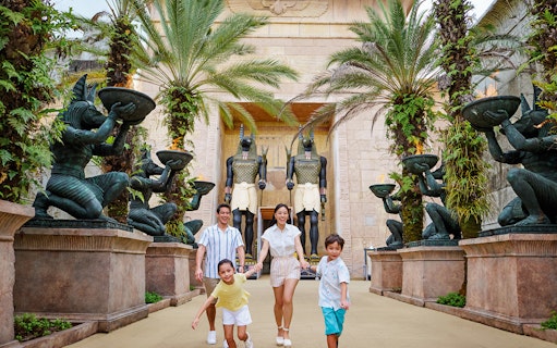 Family with toddlers at Egypt Zone, Universal Studios Singapore, surrounded by Anubis statues.