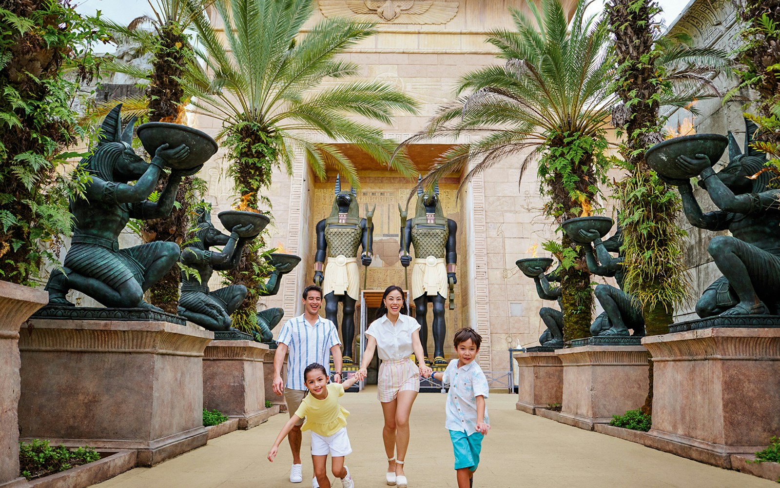 Family with toddlers at Egypt Zone, Universal Studios Singapore, posing near ancient Egyptian statues.