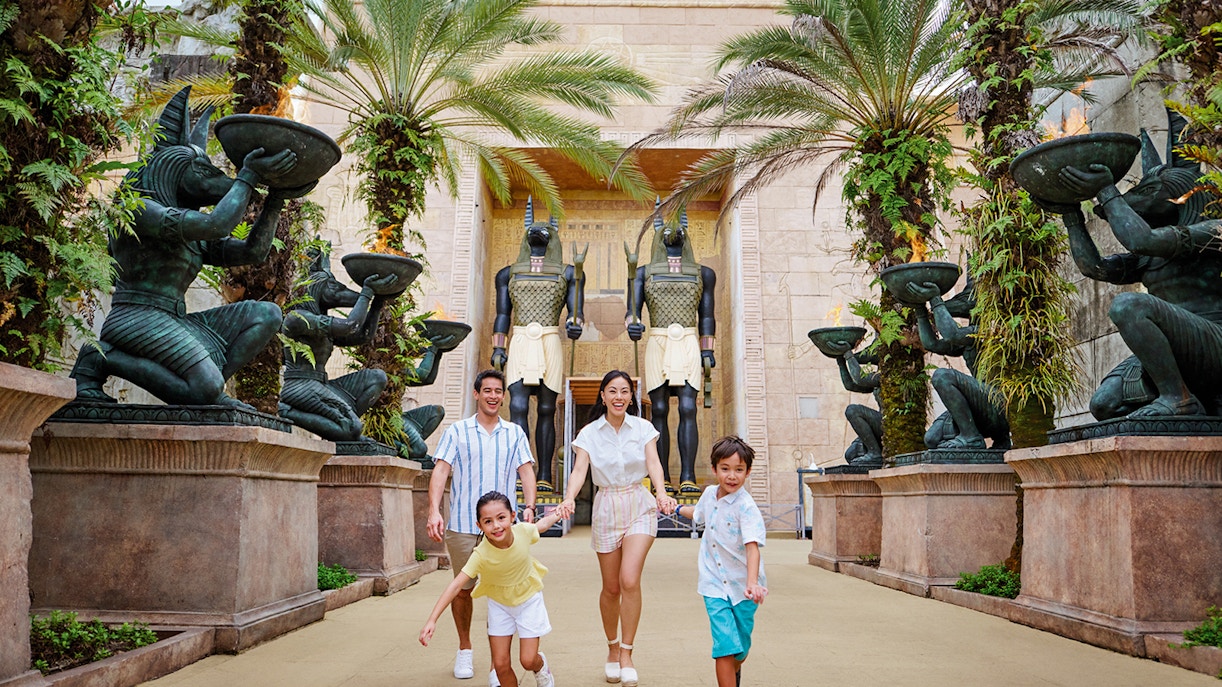 Family with toddlers at Egypt Zone, Universal Studios Singapore, posing near ancient Egyptian statues.