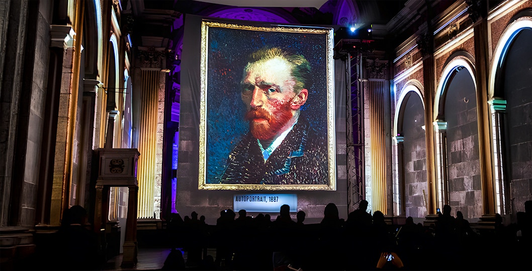 Van Gogh self-portrait displayed at London exhibition with guests viewing.