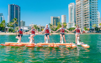 Tourists riding waterbikes on the Gold Coast with city skyline in the background.