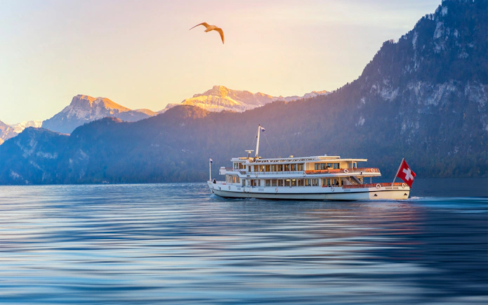 Steamboat cruising on Lake Lucerne with Swiss Alps in the background.