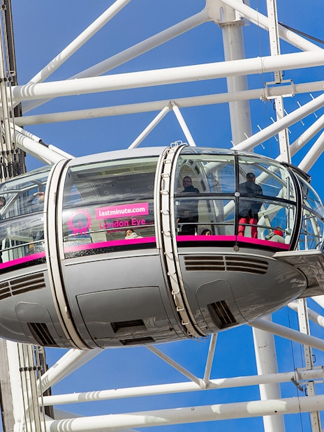 London Eye pod with passengers against a blue sky.