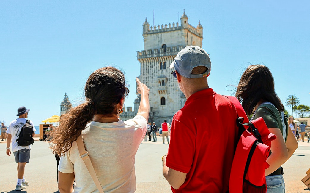 Tourists observing Belém Tower in Lisbon during a small group tour.