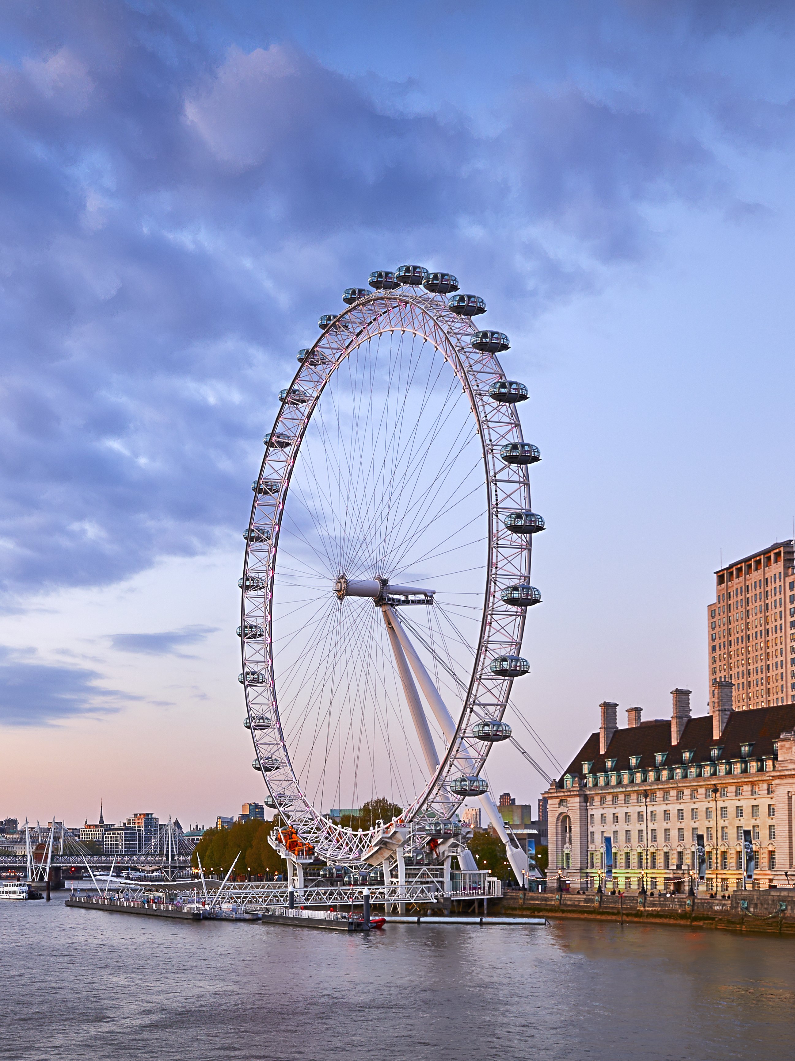 London Eye overlooking the Thames River at sunset.