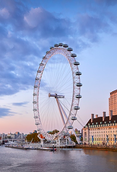 London Eye overlooking the Thames River at sunset.