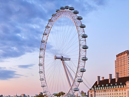 London Eye overlooking the Thames River at sunset.