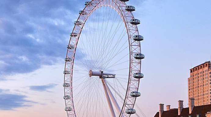 London Eye overlooking the Thames River at sunset.