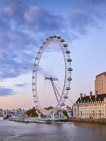 London Eye overlooking the Thames River at sunset.