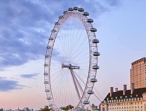 London Eye overlooking the Thames River at sunset.