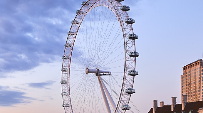 London Eye overlooking the Thames River at sunset.