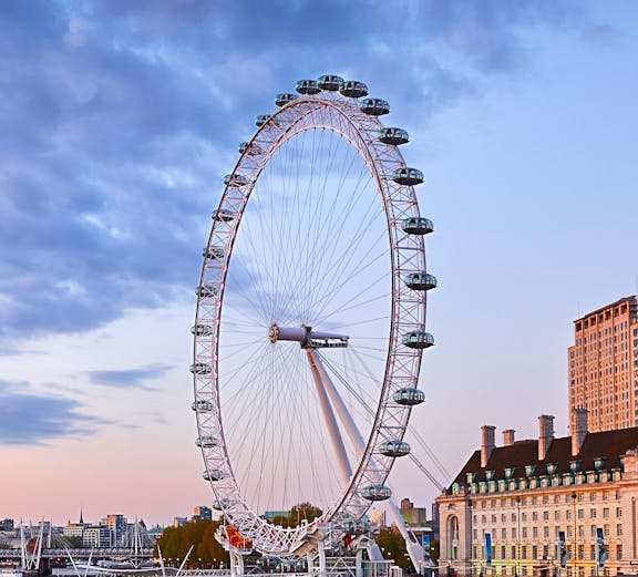 London Eye overlooking the Thames River at sunset.