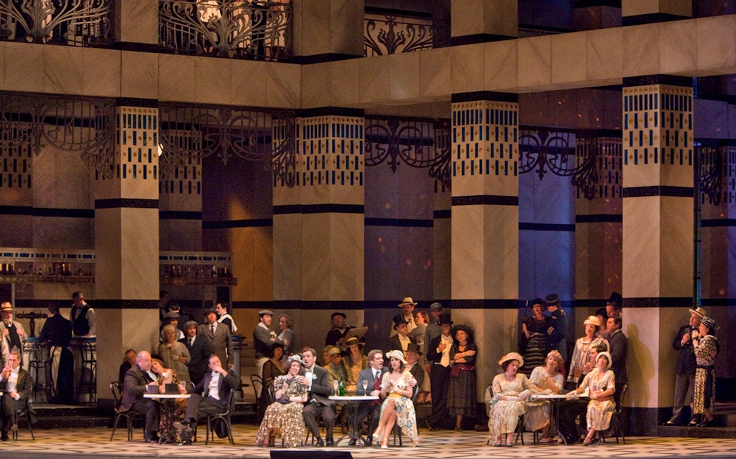 Opera performance of La Rondine with elegantly dressed audience in a grand theater setting.