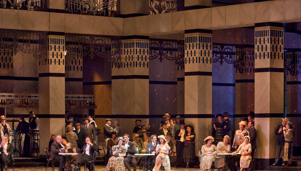 Opera performance of La Rondine with elegantly dressed audience in a grand theater setting.