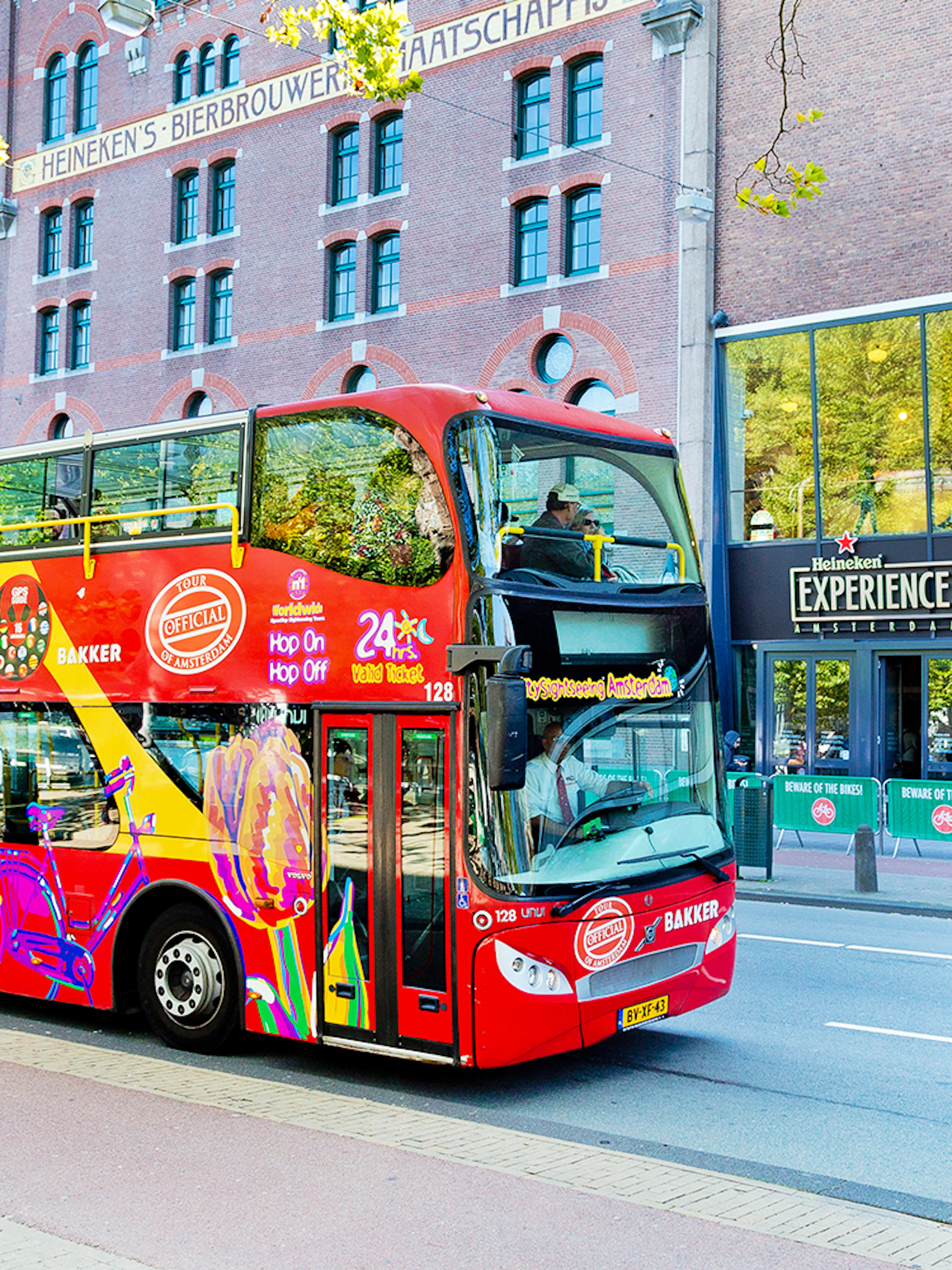 Red double-decker bus on Amsterdam Hop-On Hop-Off tour near Heineken Experience.