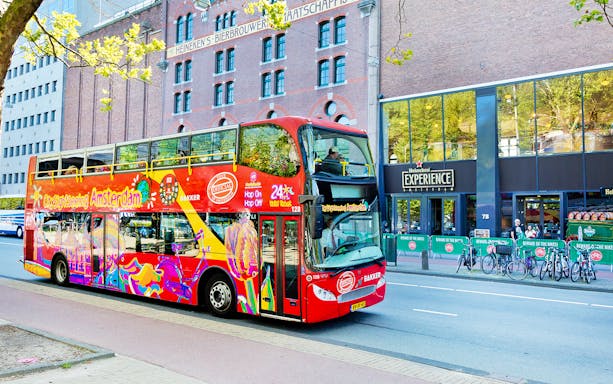 Red double-decker bus on Amsterdam Hop-On Hop-Off tour near Heineken Experience.