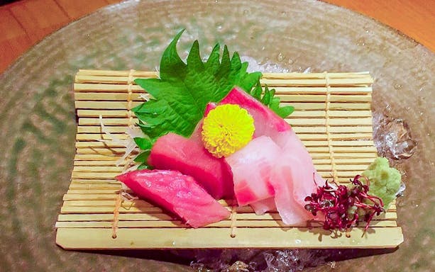Sashimi platter with garnish on bamboo mat, part of Gion walking tour with Kaiseki dinner.