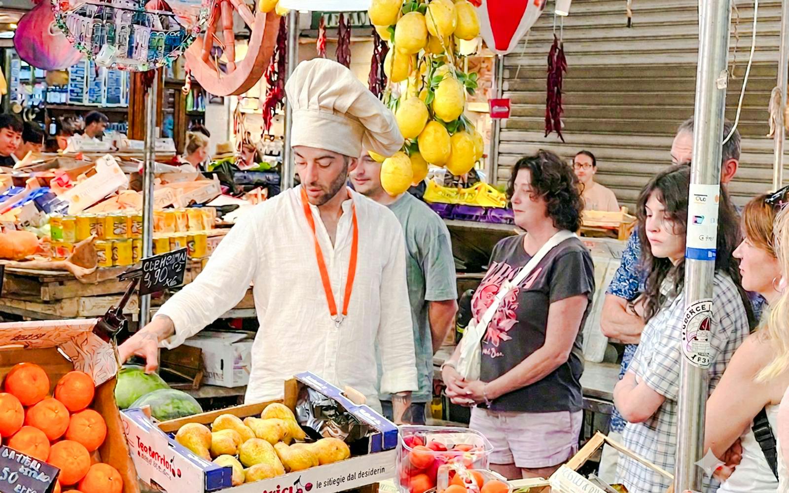 Chef guiding a small group through a Florence market during a cooking class.