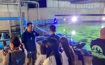 Guide explaining aquarium features to visitors at Angkor Wildlife & Aquarium, Siem Reap.