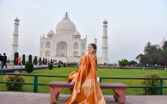 Visitor in traditional attire at the Taj Mahal, part of a private day trip from Delhi to Agra.