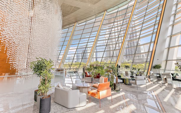 Dubai Opera interior lounge with modern seating and large windows overlooking cityscape.