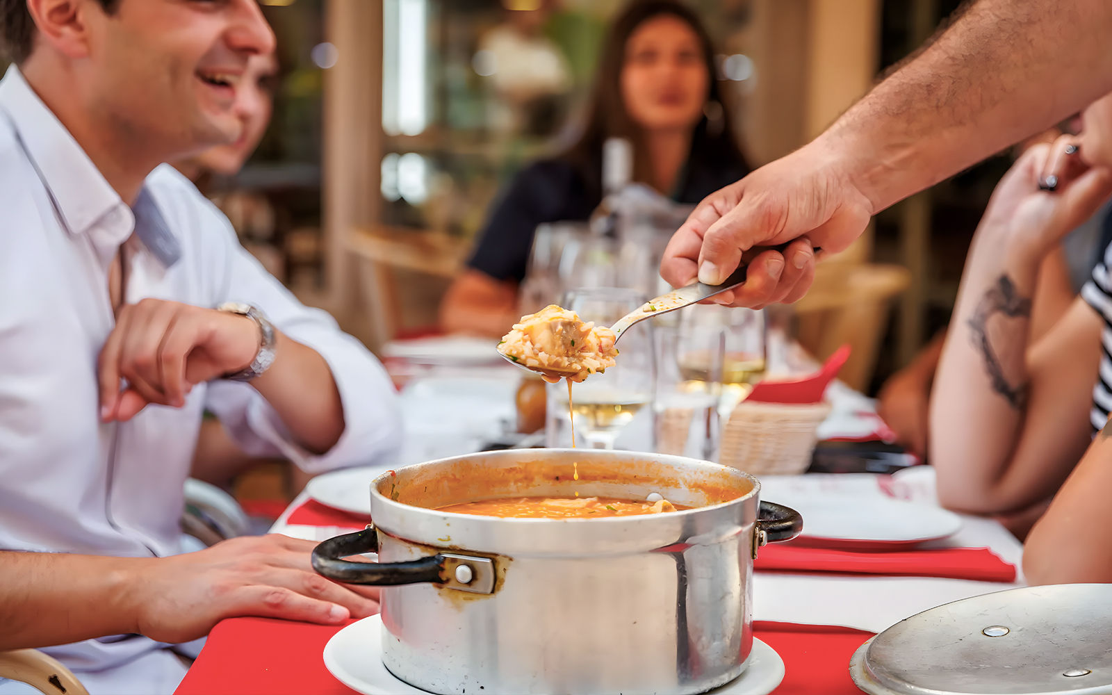 Tourist enjoying traditional dish with guide at Lisbon restaurant during Baixa food walk.