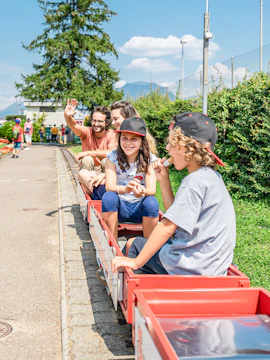 Children riding a miniature train at Swissminiatur park in Switzerland.