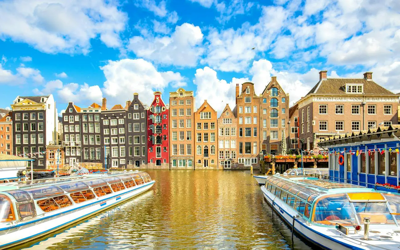 Canal boats and historic gabled buildings in Amsterdam, part of the self-guided city exploration game.