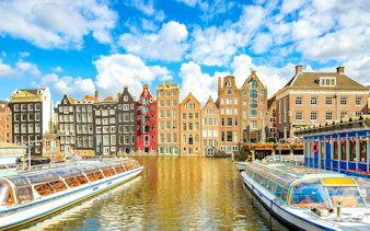 Canal boats and historic gabled buildings in Amsterdam, part of the self-guided city exploration game.