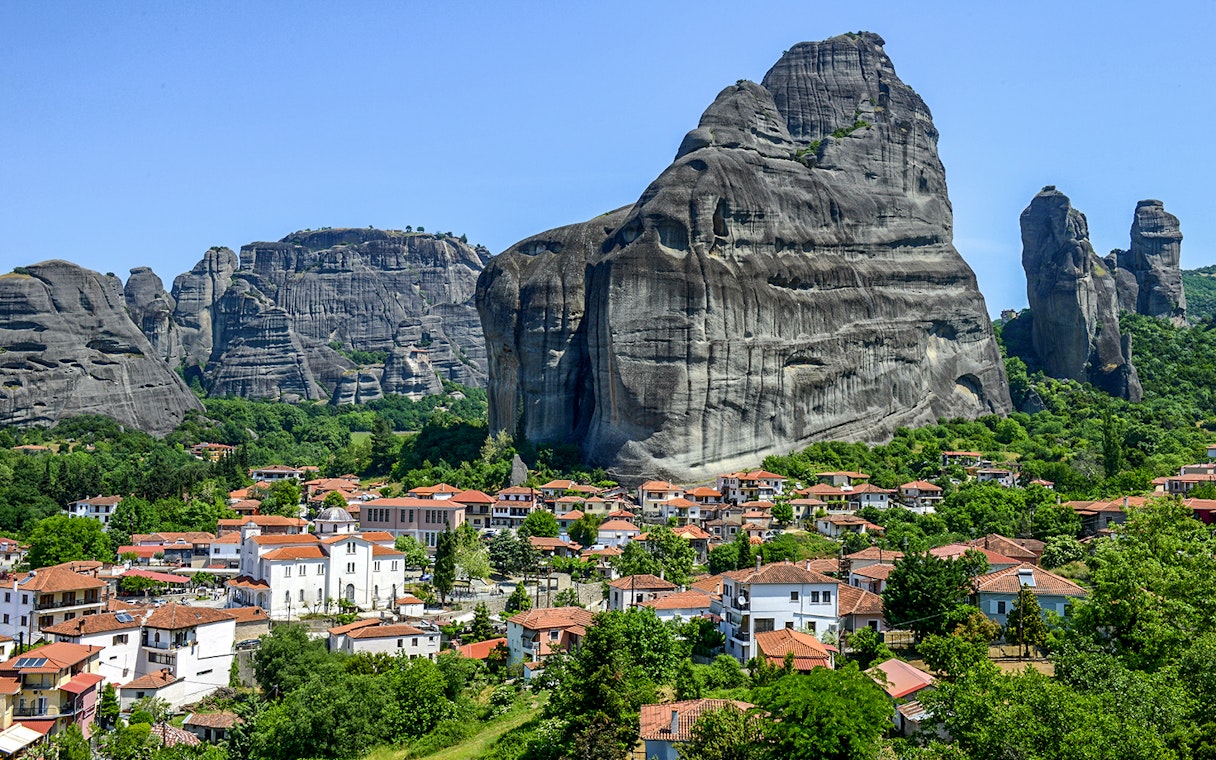 Meteora rock formations with monasteries above a village in Greece.