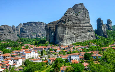 Meteora rock formations with monasteries above a village in Greece.