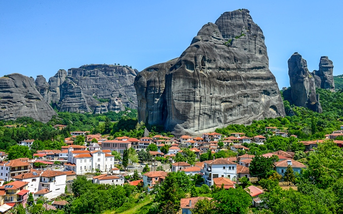 Meteora rock formations with monasteries above a village in Greece.