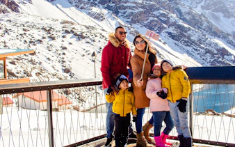Family taking a selfie at snowy Portillo with Laguna del Inca in the background, Santiago.