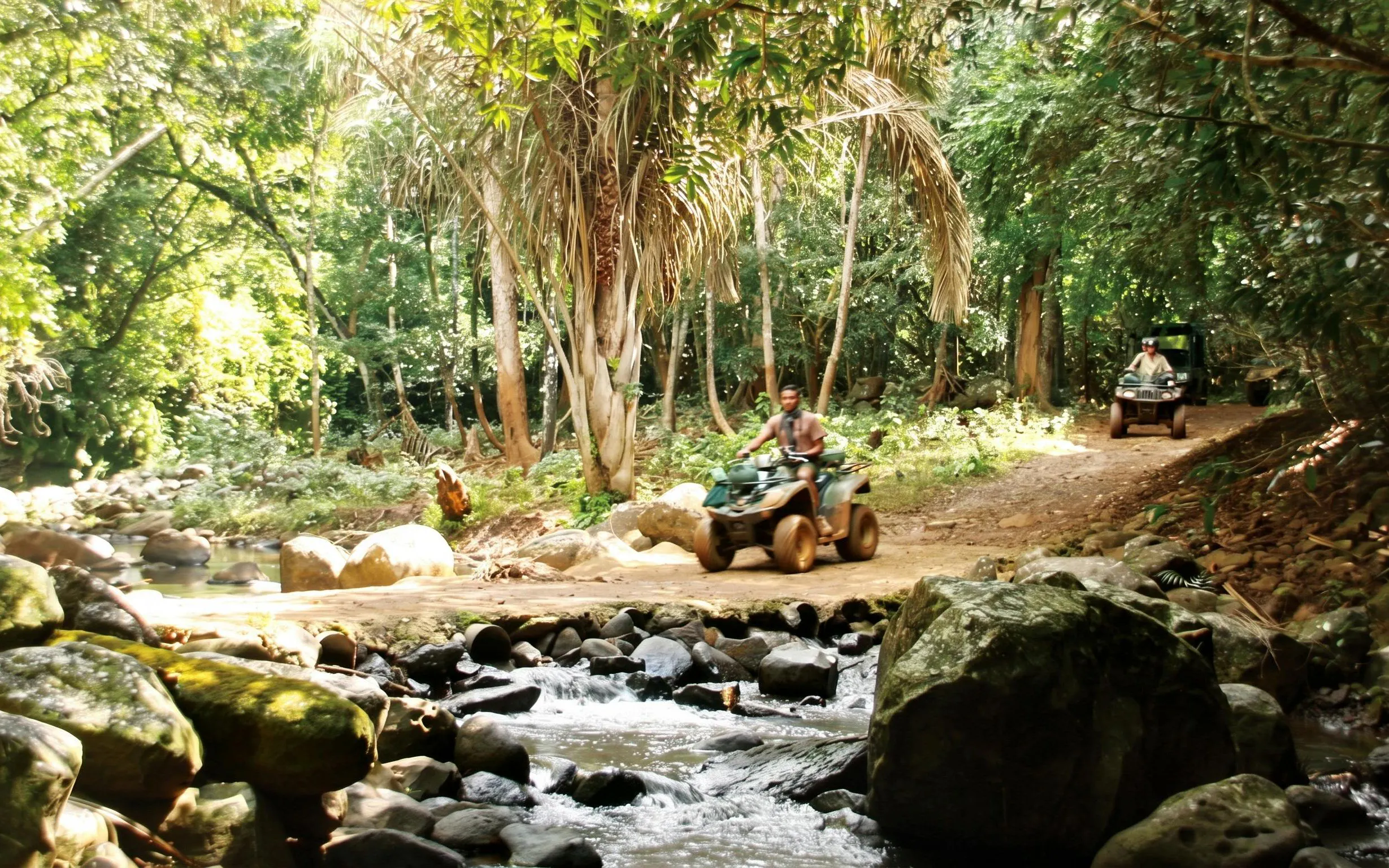 ATV riders on Bel Ombre walking trail through lush forest.