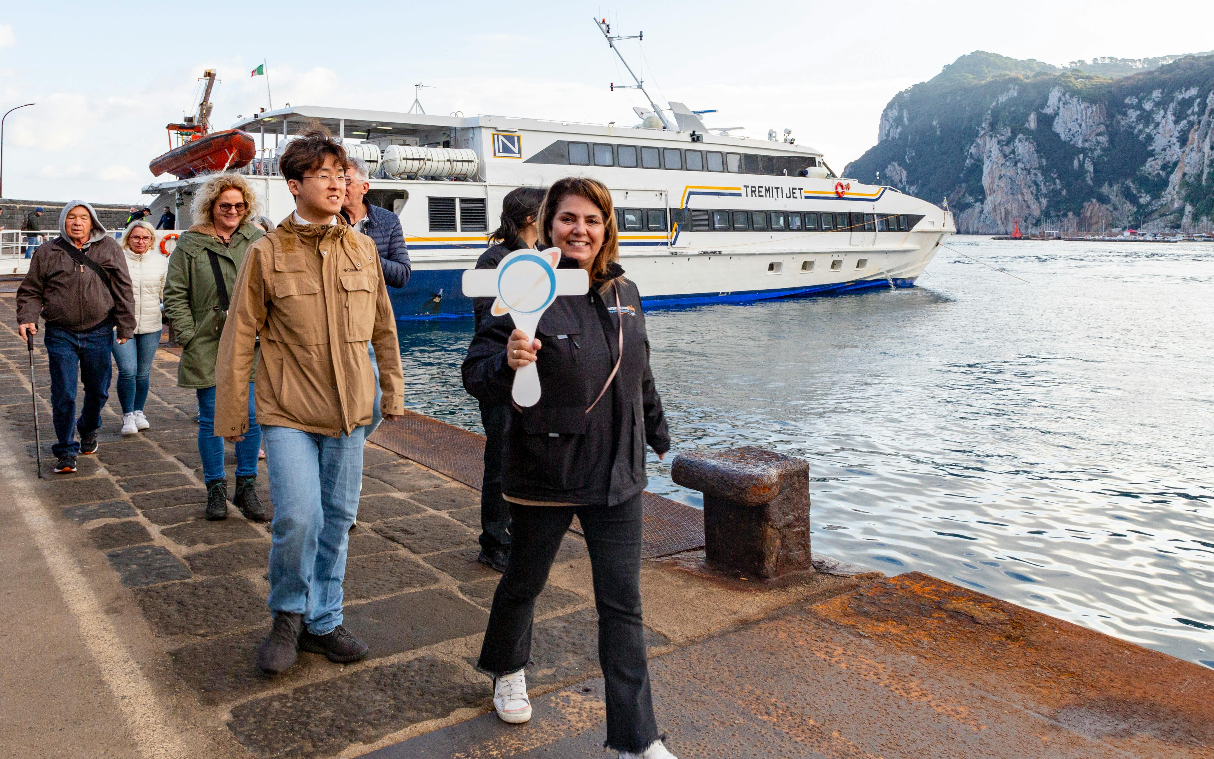 Tourists with guide at cruise dock during Capri tour.