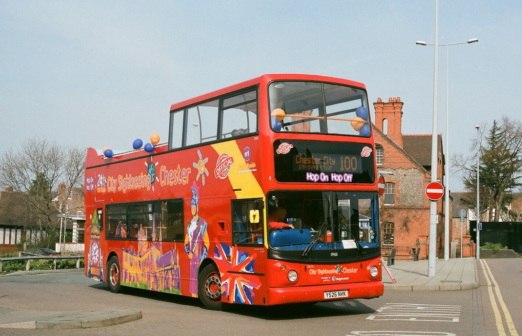 Chester double-decker bus near historic city walls on 24/48-Hr Hop-On Hop-Off Tour.