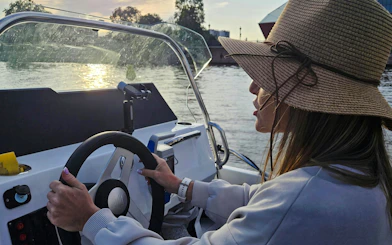 Guest steering an electric boat on a self-drive tour in Gdansk.