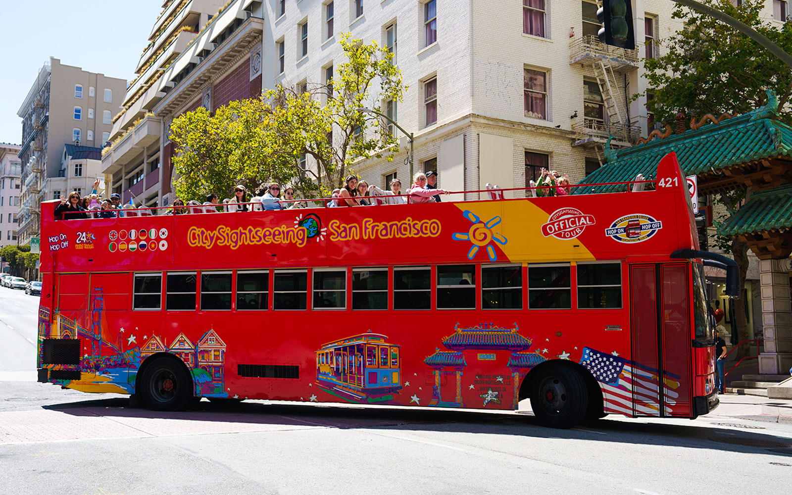 Open-top sightseeing bus in San Francisco with tourists on board.
