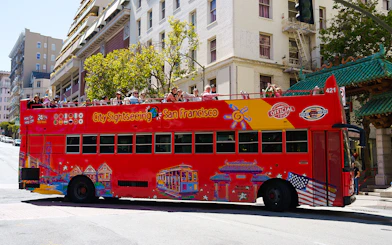 Open-top sightseeing bus in San Francisco with tourists on board.