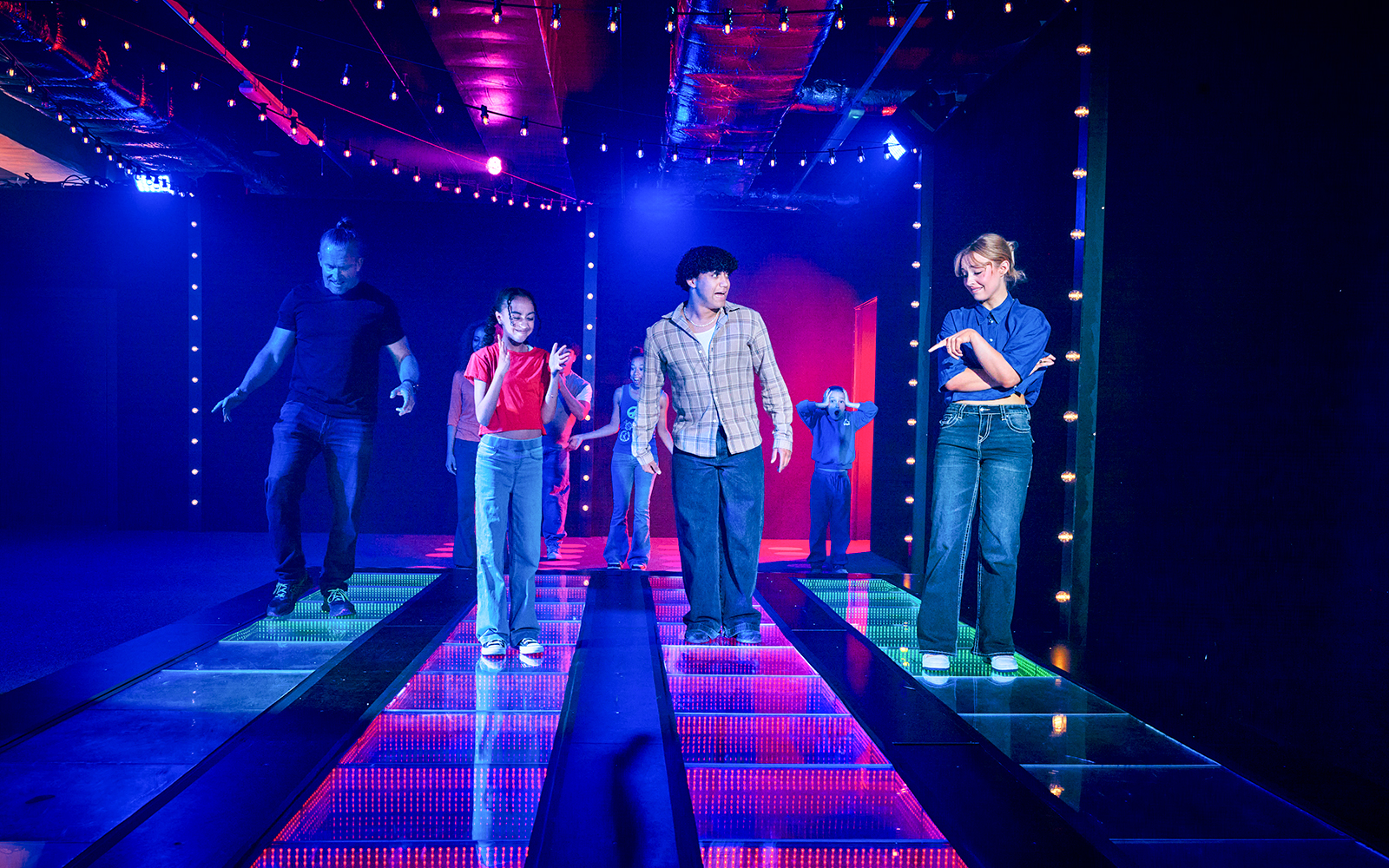 Participants navigating a glass bridge at the Squid Games experience in London.