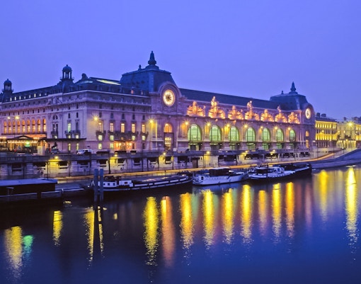 Louvre Museum view from Seine River cruise in Paris, France at night.