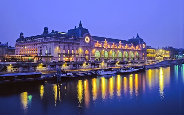Louvre Museum view from Seine River cruise in Paris, France at night.