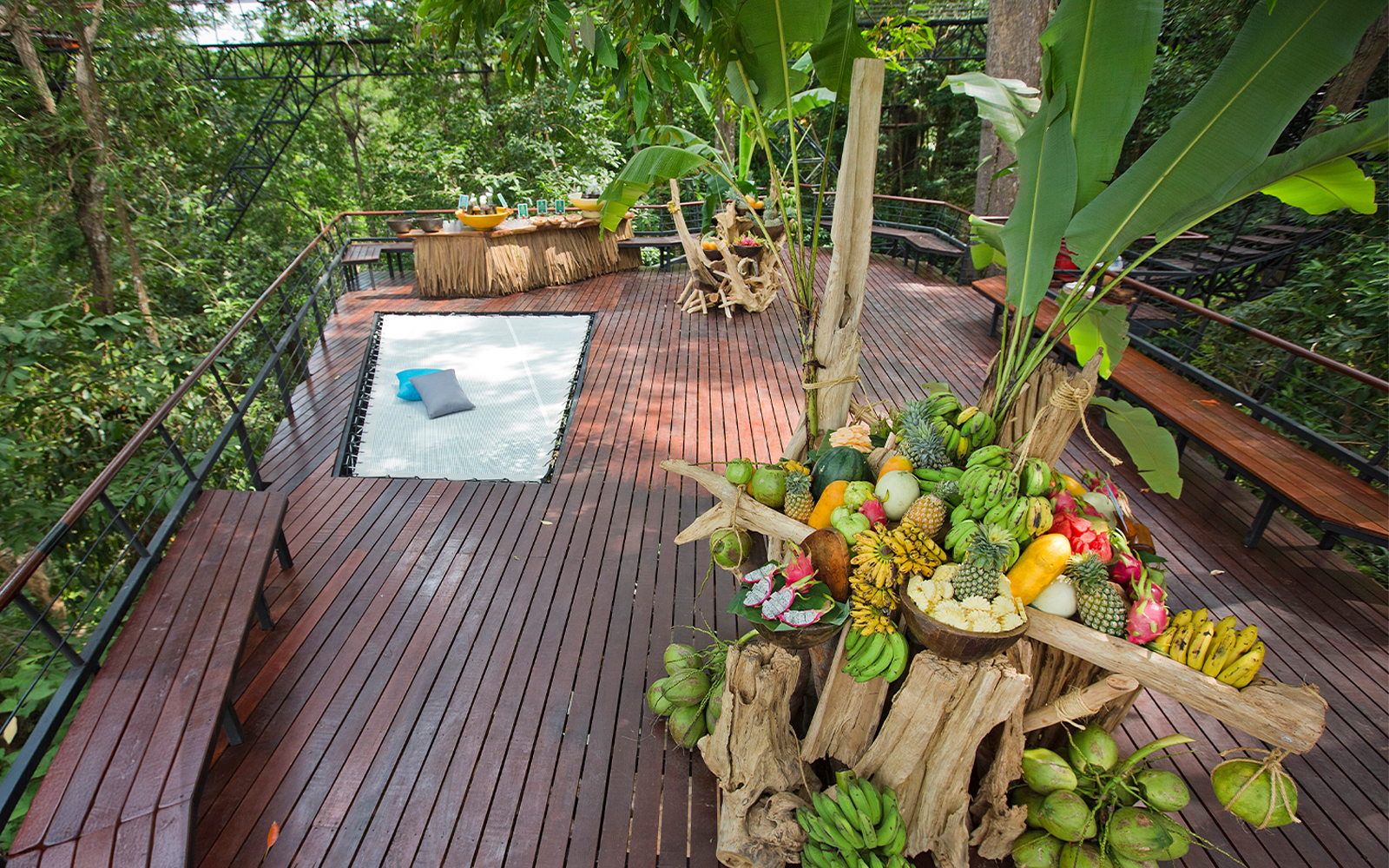 Fruit display and seating area on a wooden deck at Hanuman World, Phuket.