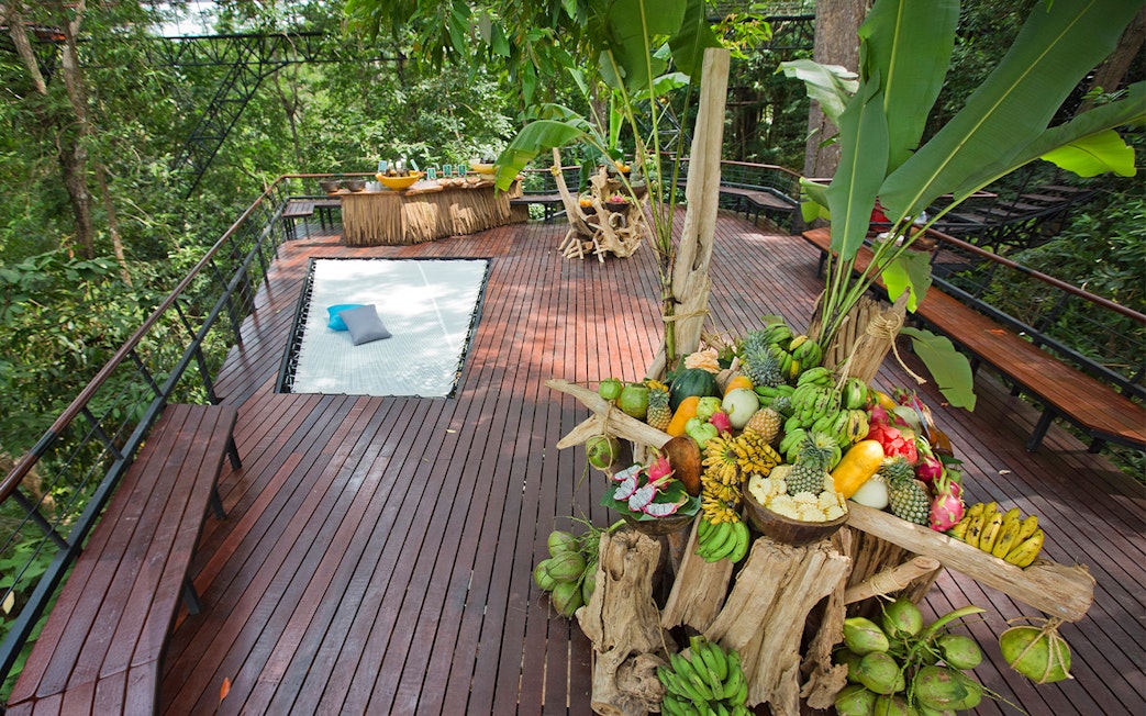 Fruit display and seating area on a wooden deck at Hanuman World, Phuket.