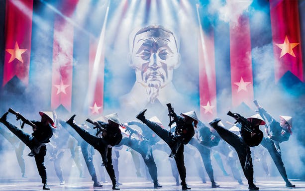 Performers in traditional hats dance on stage during Miss Saigon in Sydney.