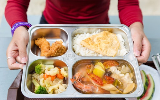 Buffet meal with rice, fried chicken, vegetables, and seafood soup on Similan Island.