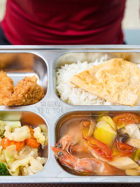 Buffet meal with rice, fried chicken, vegetables, and seafood soup on Similan Island.