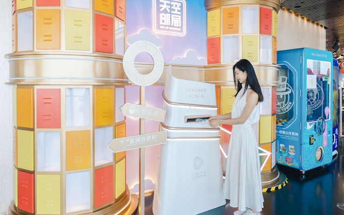 Woman interacting with a colorful display at Shanghai Tower's observation deck.